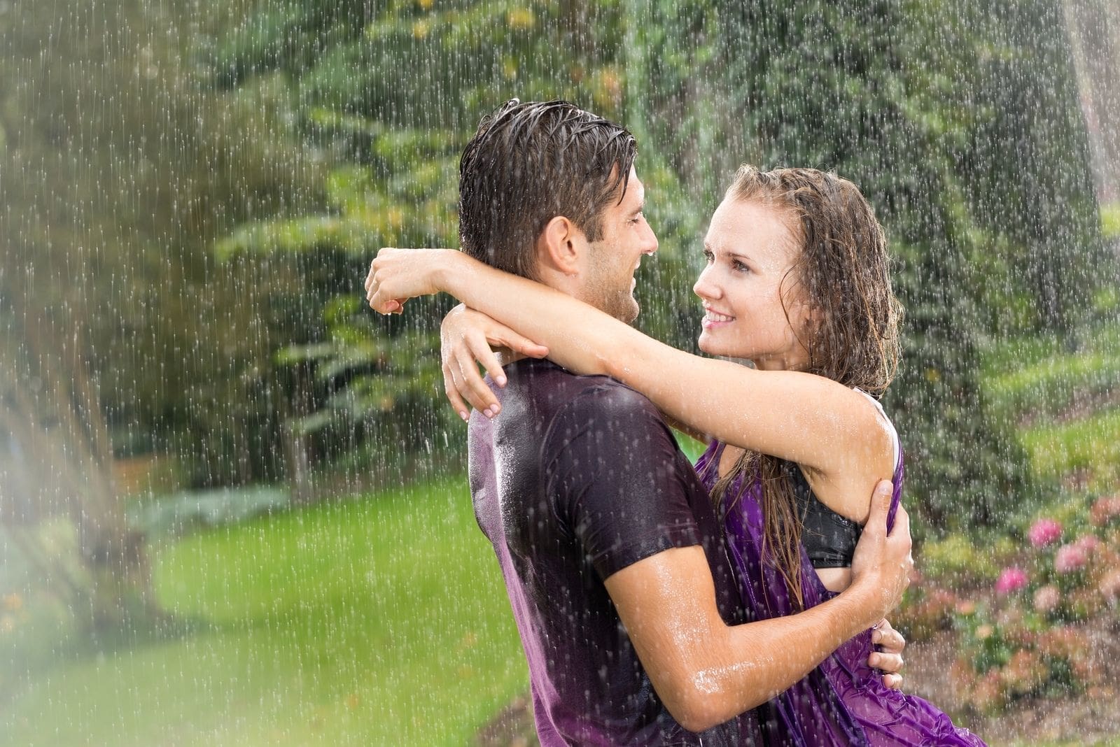 pareja bajo la lluvia abrazándose empapándose de agua de lluvia al aire libre