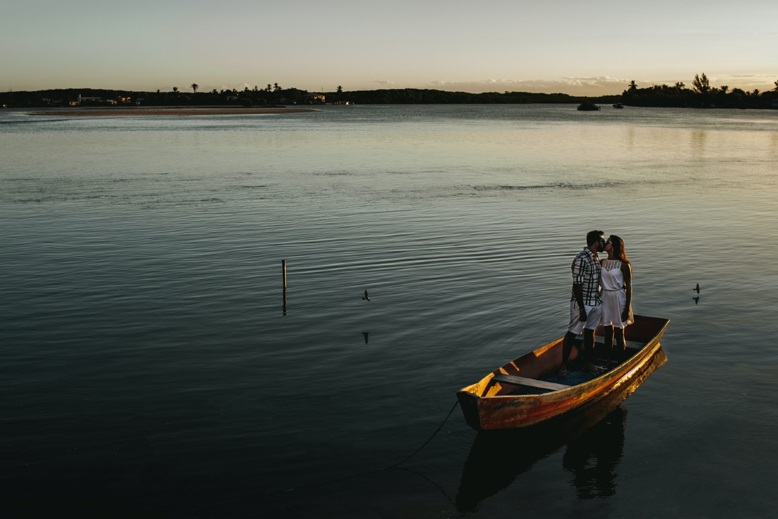 homem e mulher a beijarem-se em pé num barco