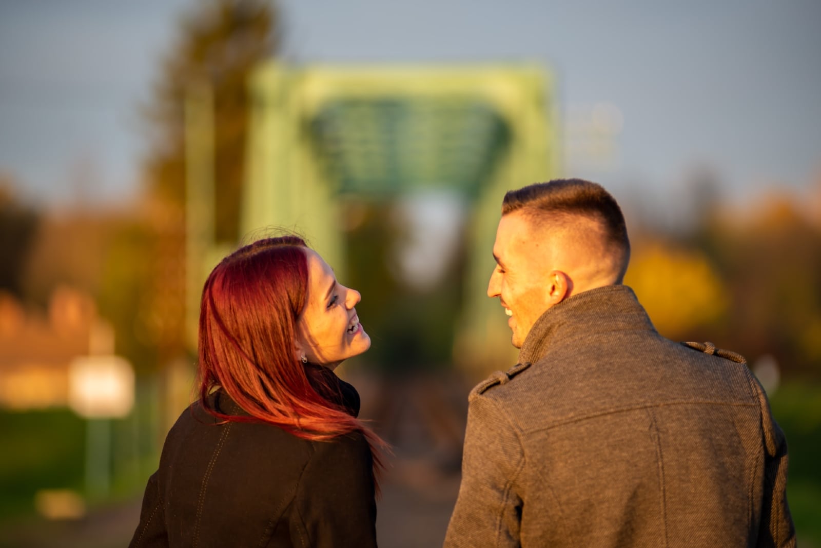 hombre y mujer riendo de pie al aire libre