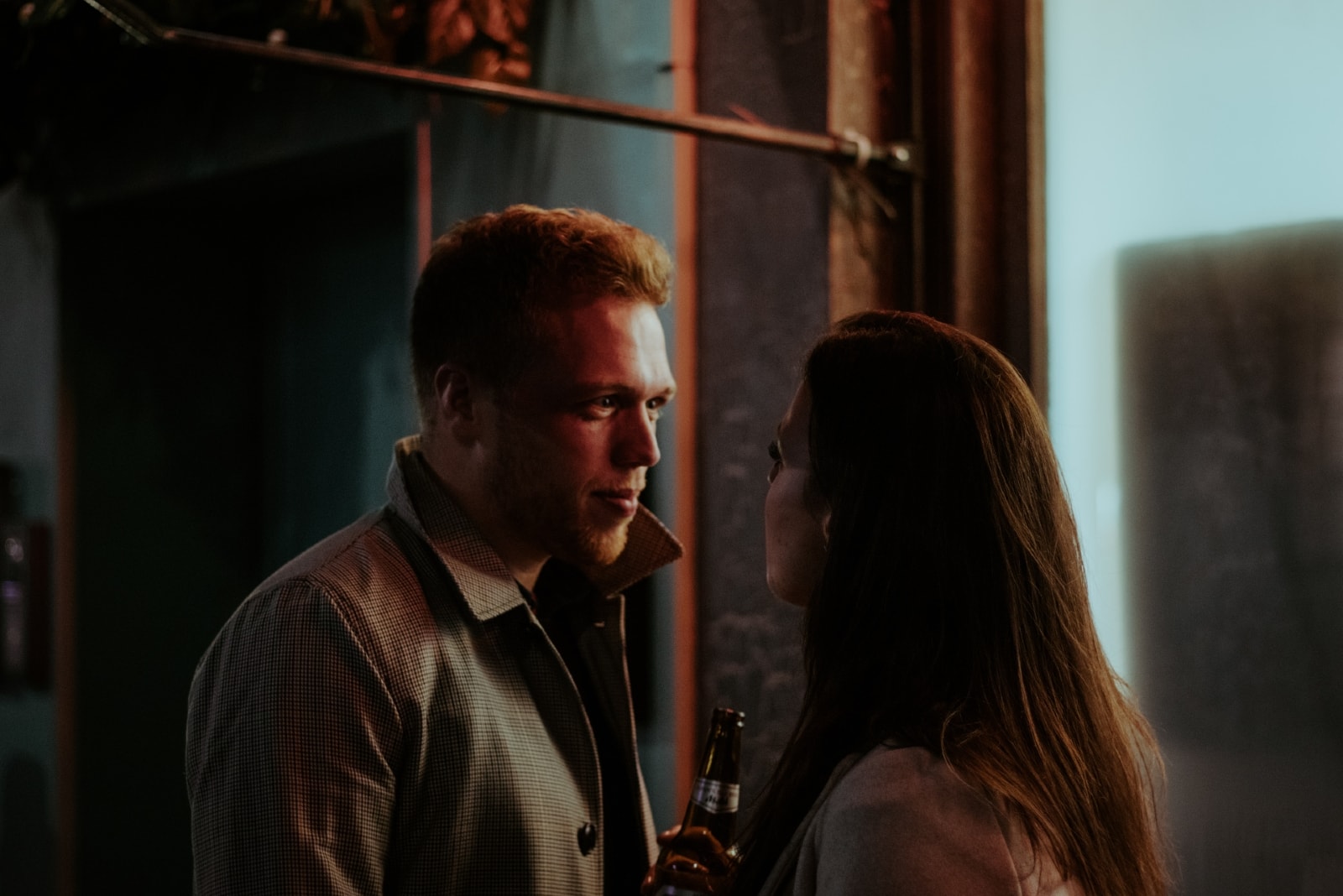 man and woman making eye contact while standing indoor