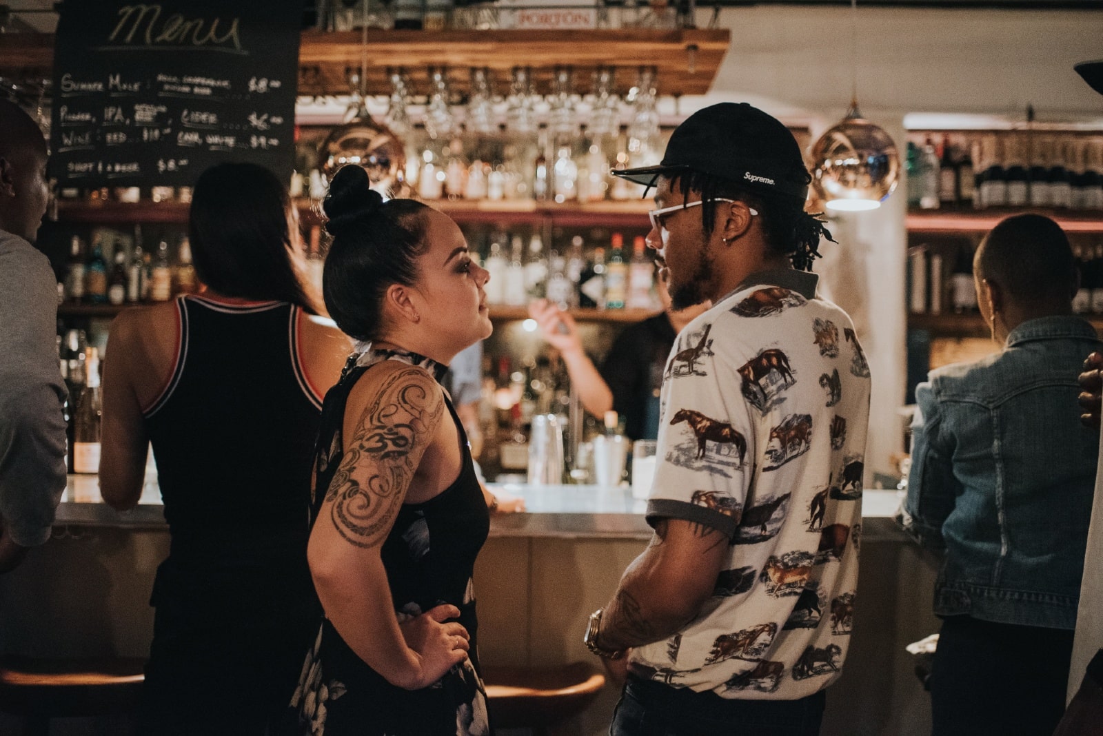 man and woman making eye contact while standing in bar