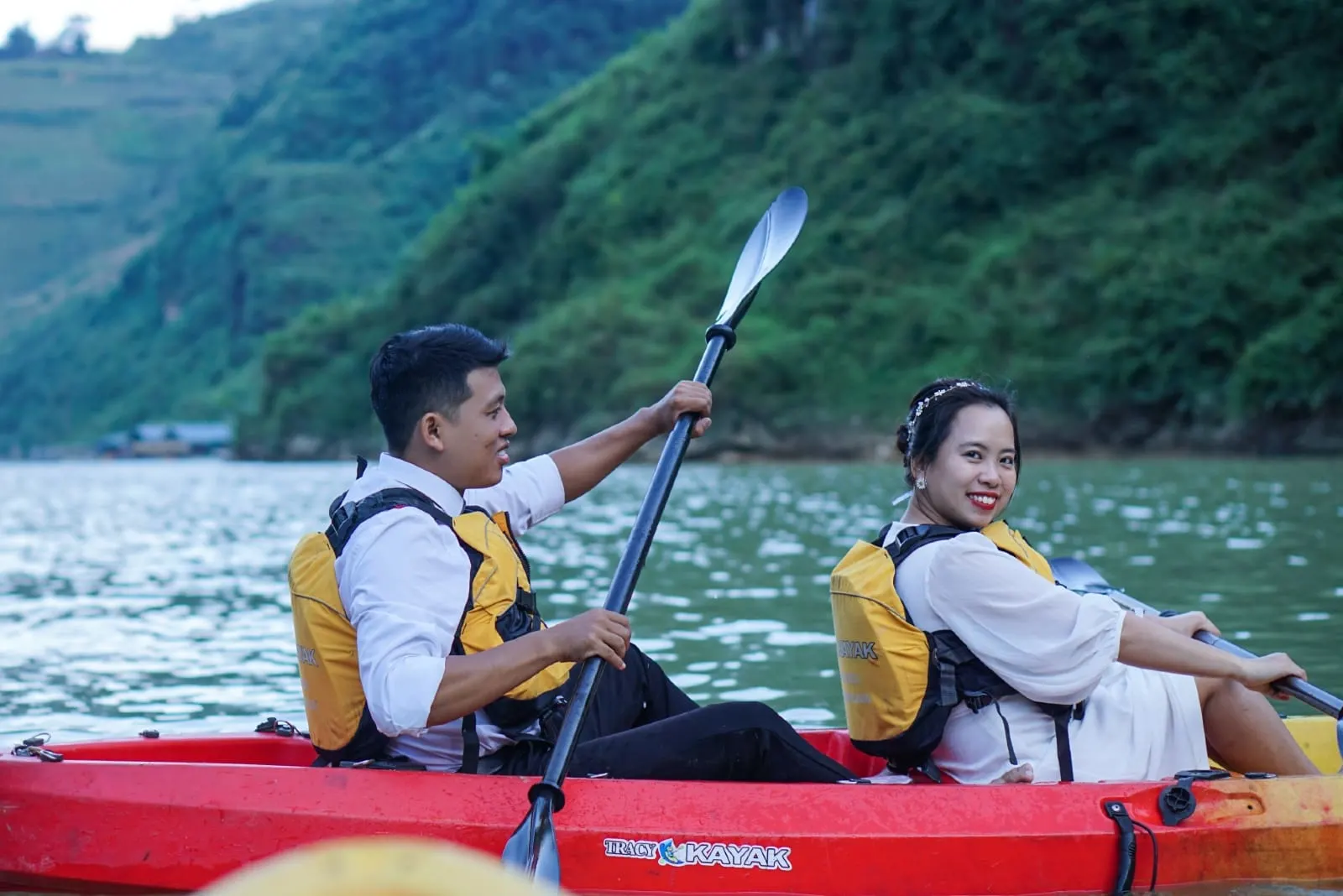 man and woman riding red kayak on lake