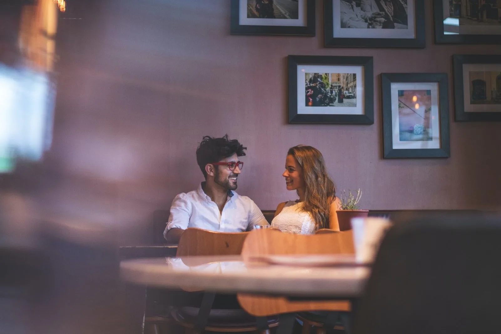man and woman making eye contact while sitting at table