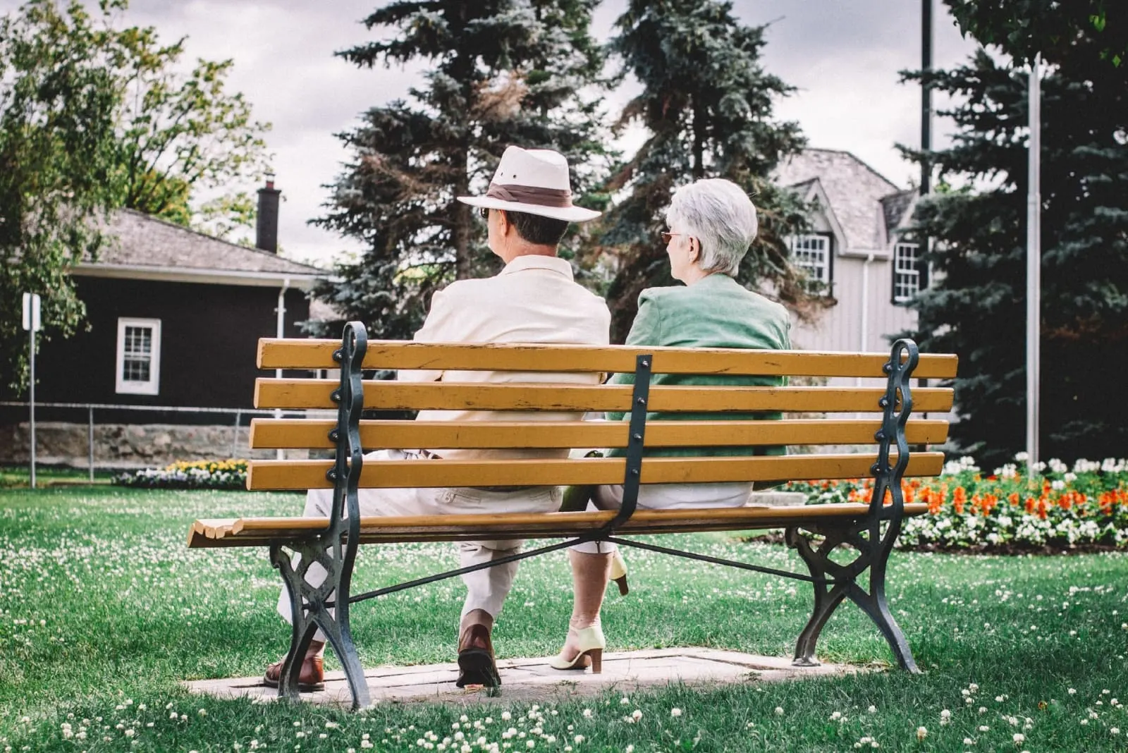 man with hat and woman sitting on bench