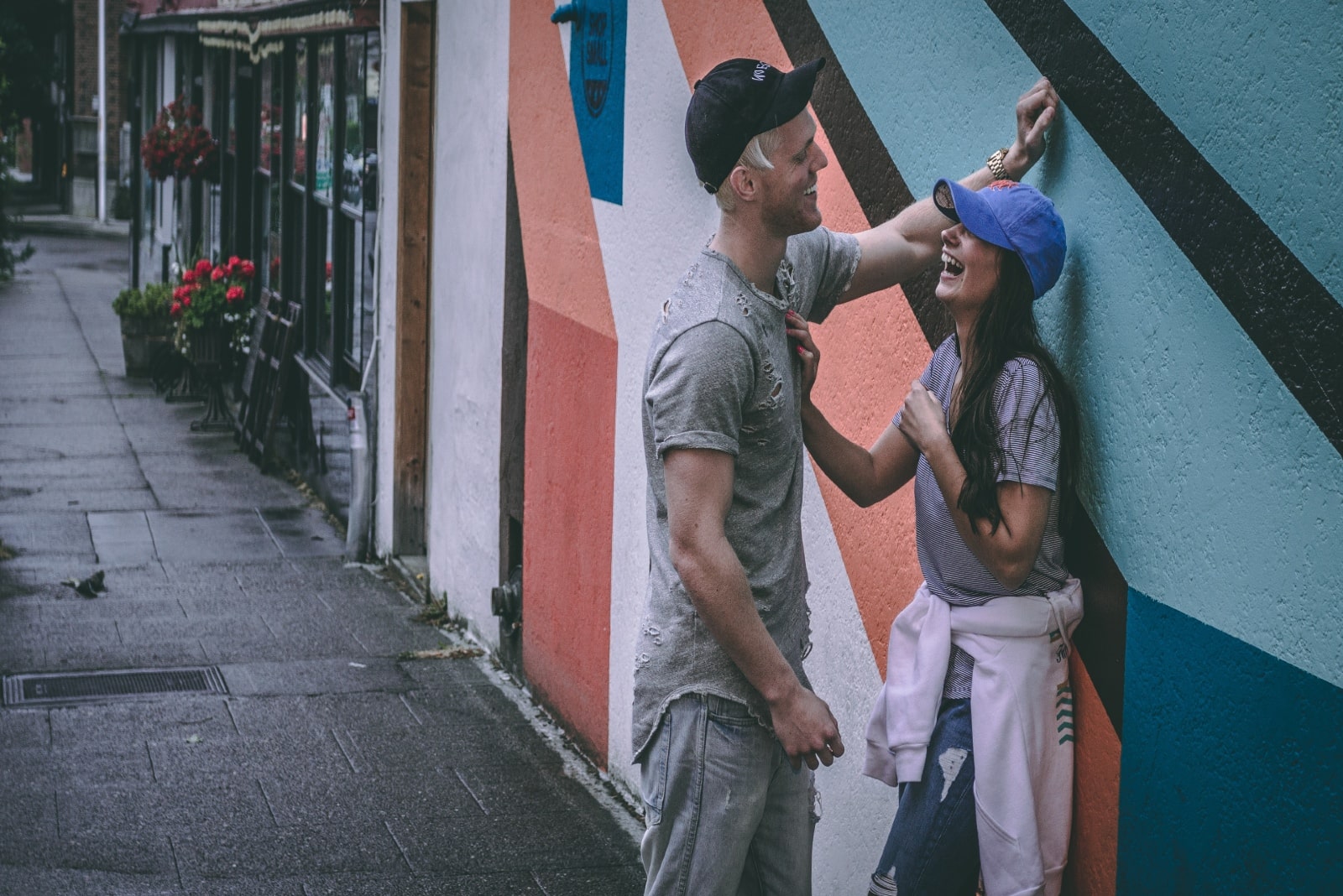 man and woman making eye contact while standing near wall