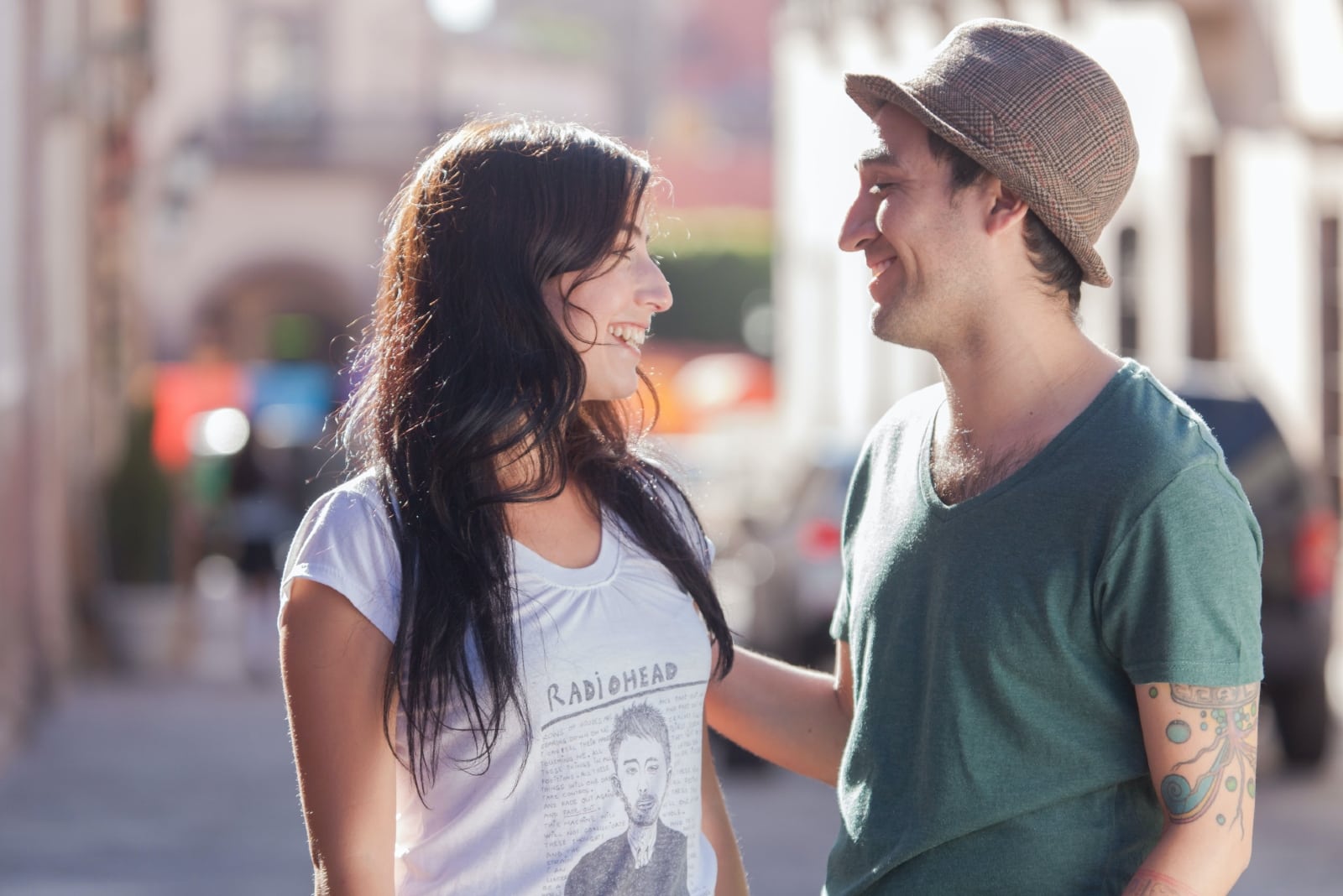 man and woman talking while standing on the street