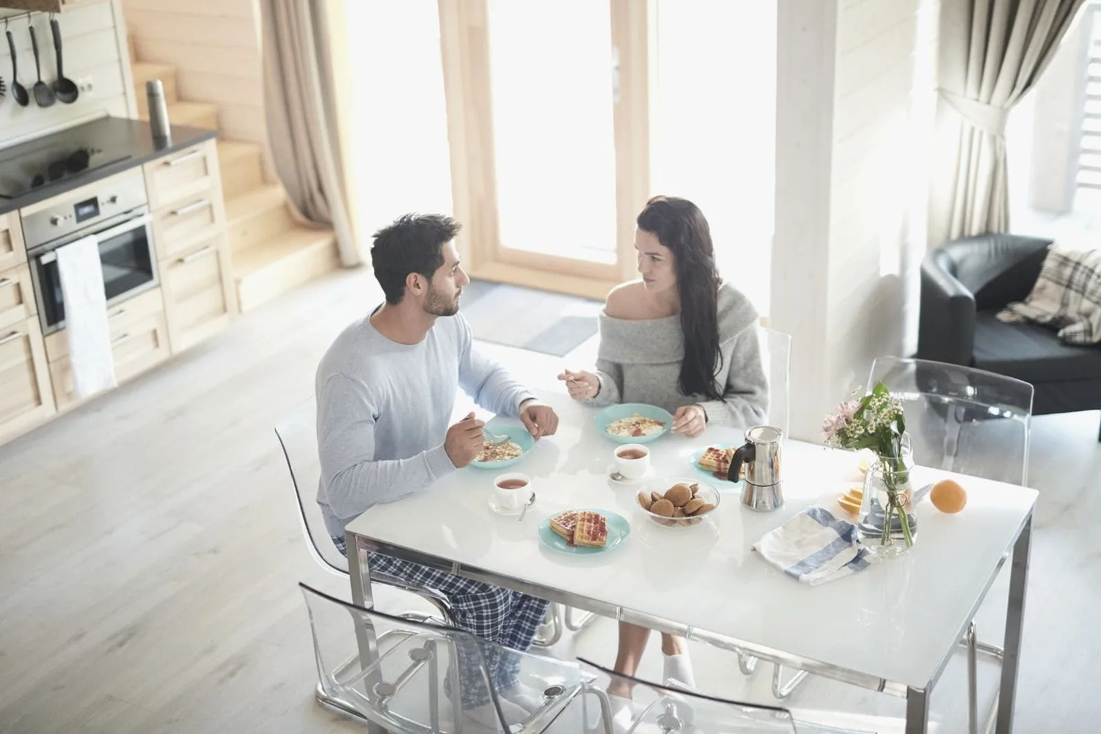 couple talking seriously during breakfast at the table at high angle