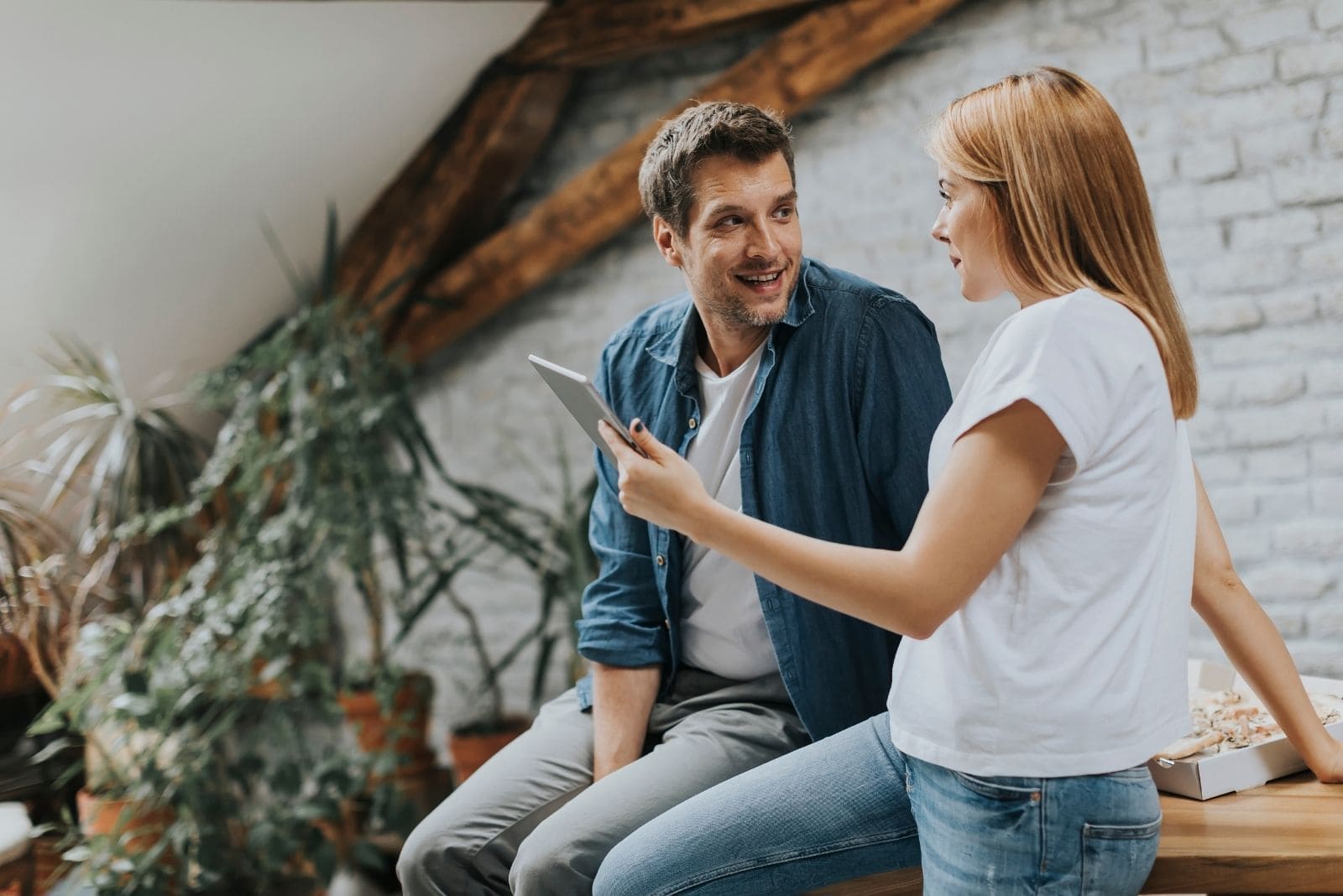 pareja usando la tablet mientras habla fuera de casa