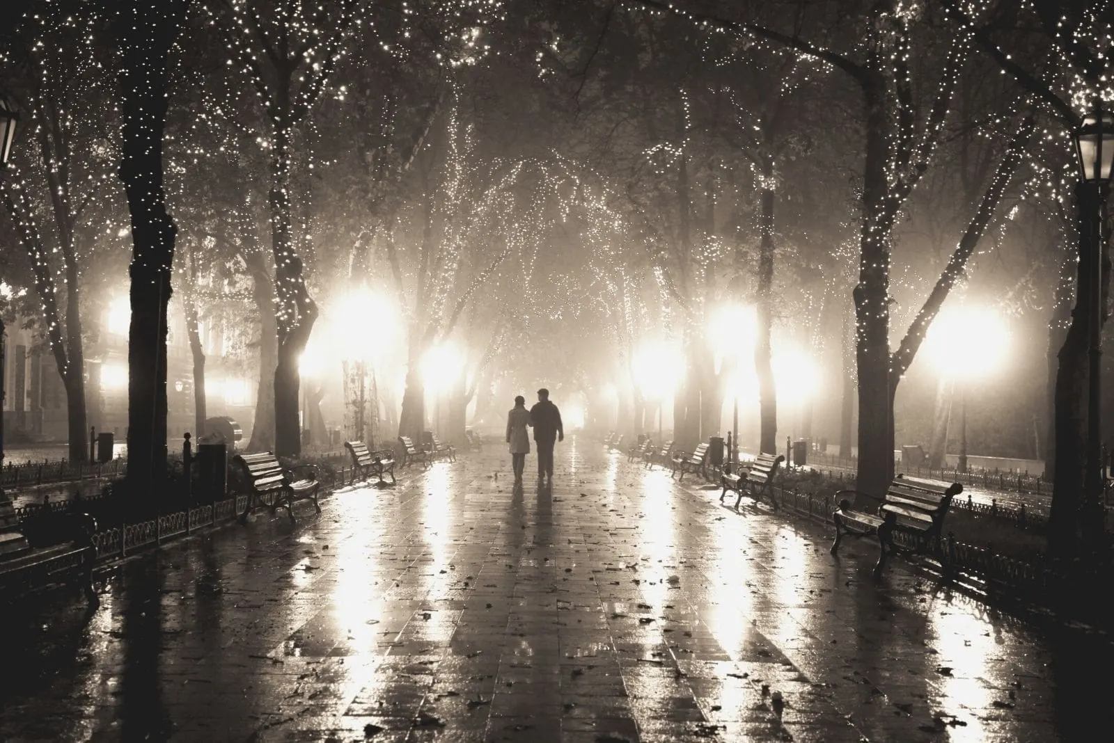 couple walkin at alley in night lights in a distant