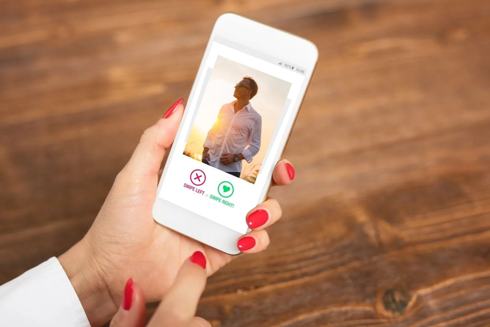 cropped hand of a woman holding a smartphone with a picture of a man in a dating app