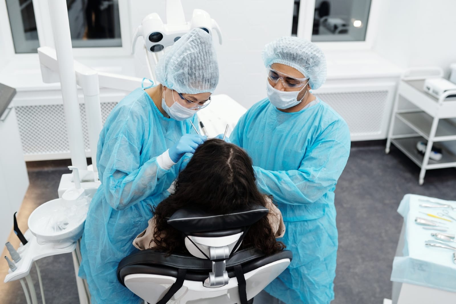 due dentisti che eseguono un'operazione odontoiatrica su un paziente