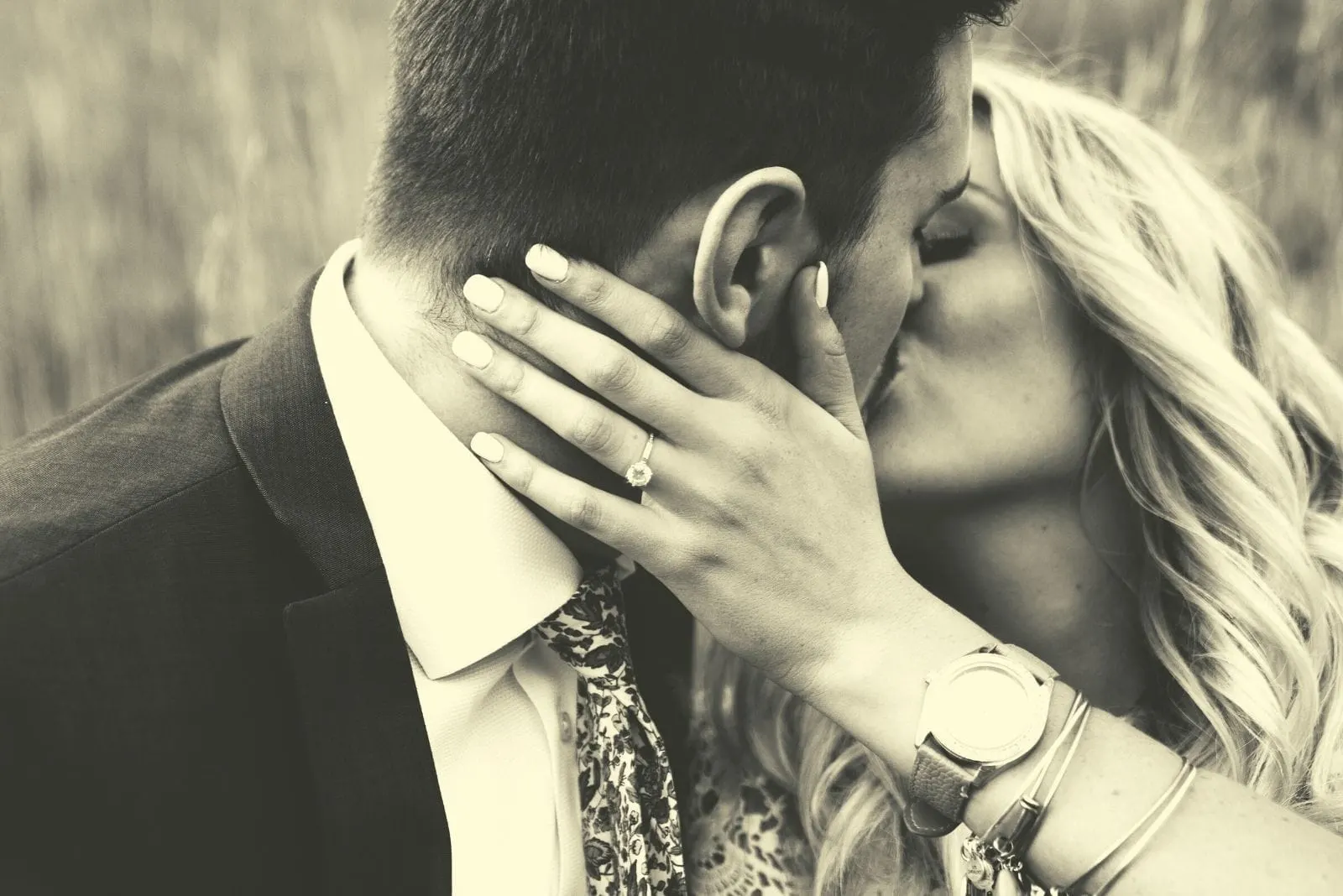 grayscale theme of kissing couple wearing formal wear outdoors