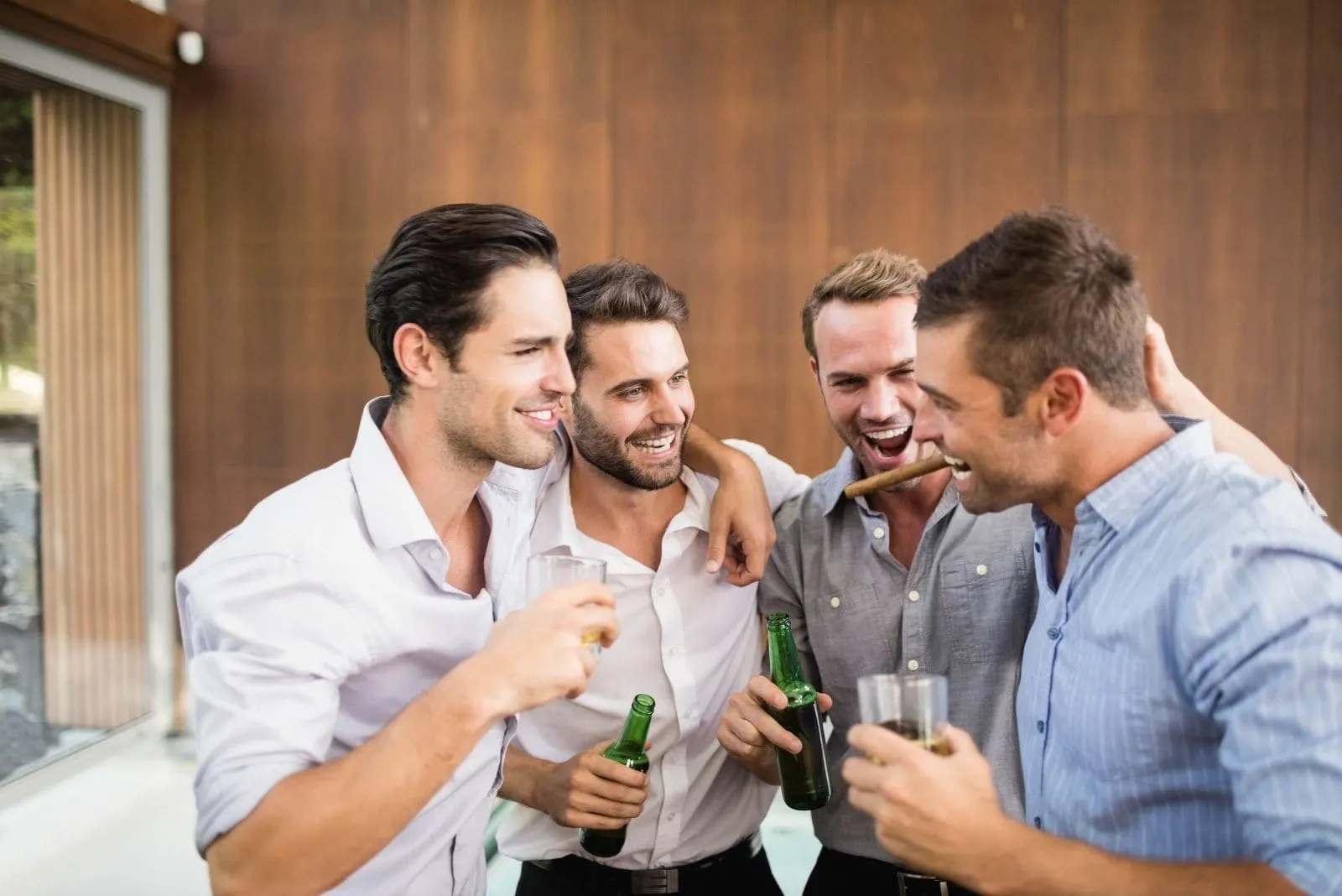 group of young men enjoying drinking inside a room in a building