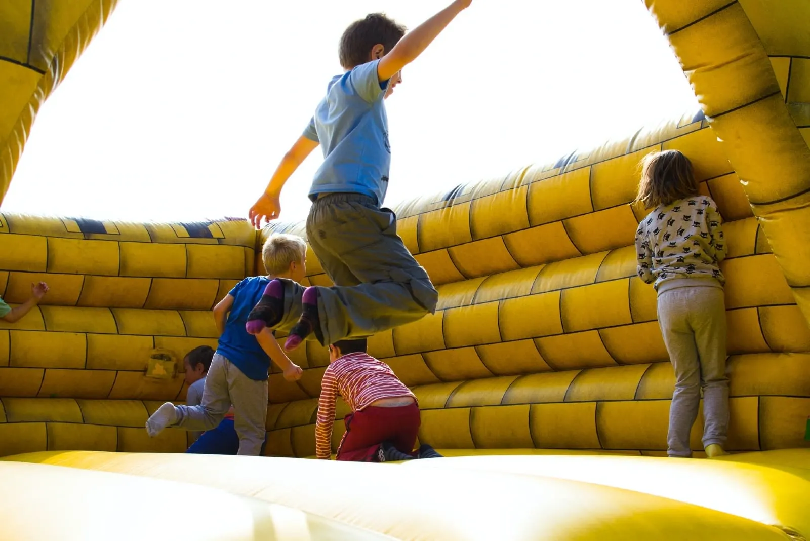 kids playing in yellow inflatable castle