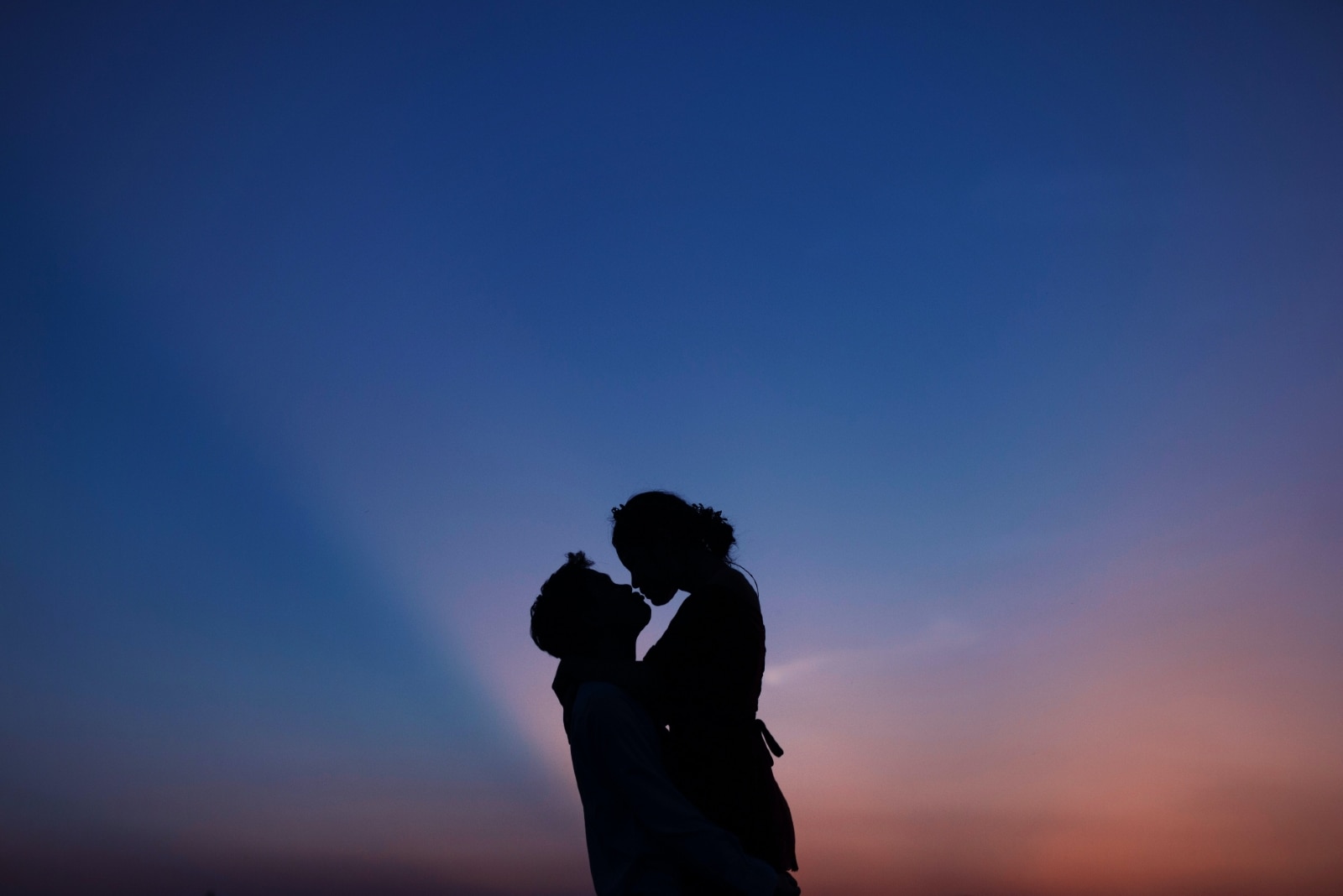 uomo che trasporta una donna durante il tramonto