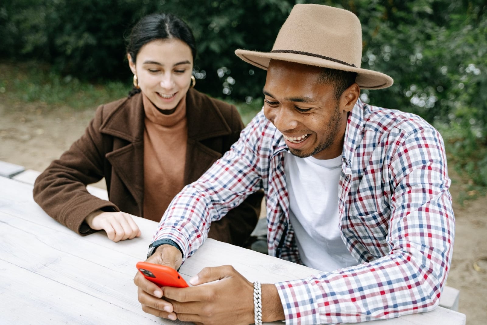 man holding phone while sitting near woman