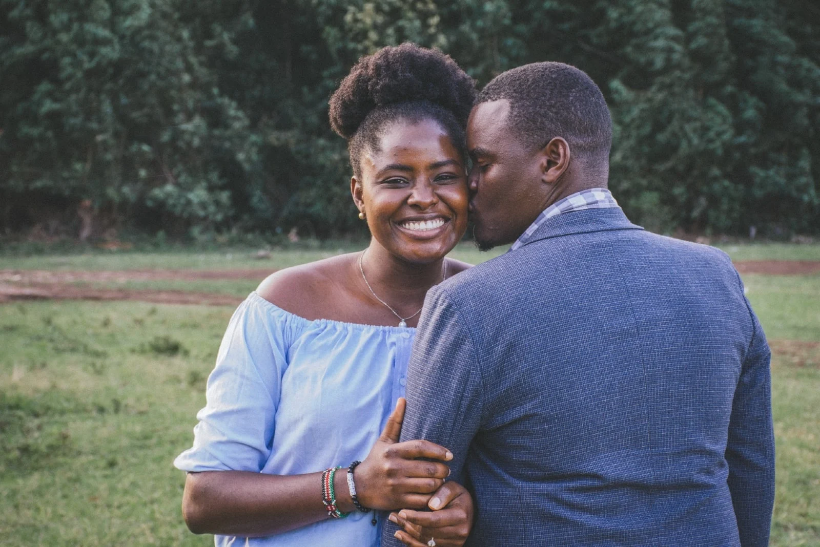 man kissing woman's cheek while standing outdoor