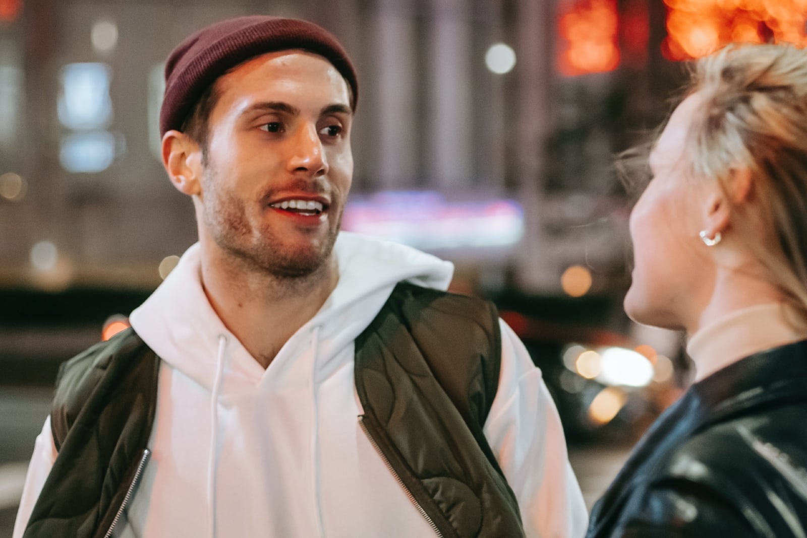 hombre feliz mirando a una mujer de pie en la calle