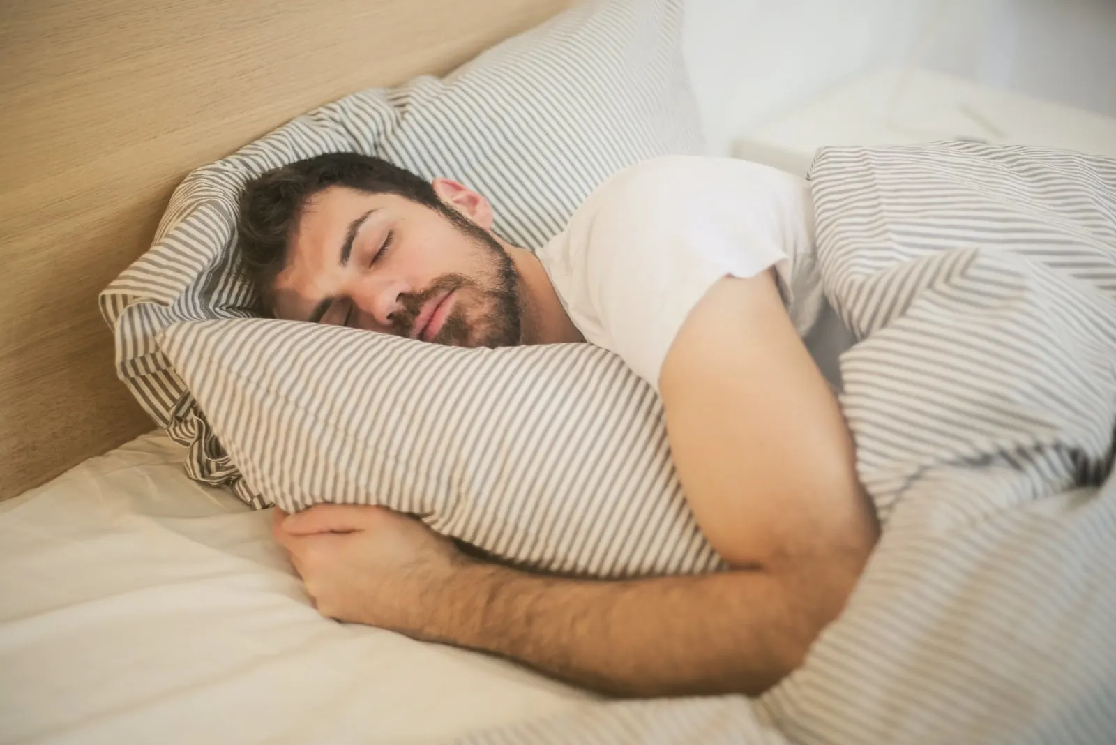 man in white t-shirt sleeping in bed