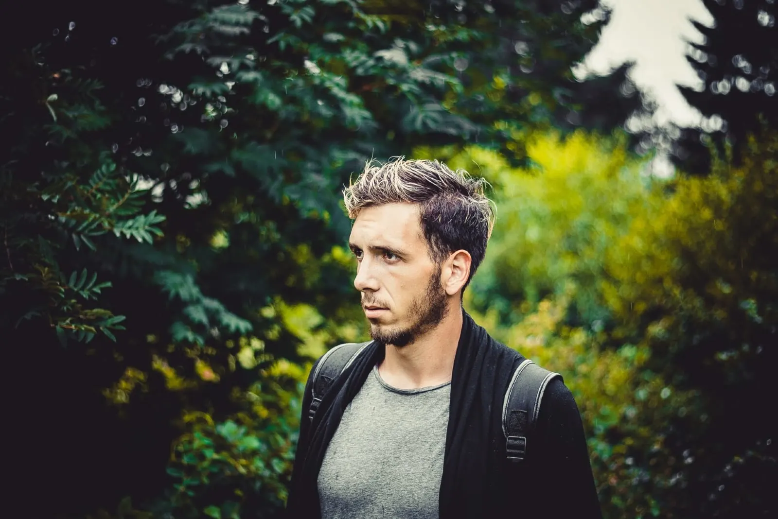 man with backpack standing near tree