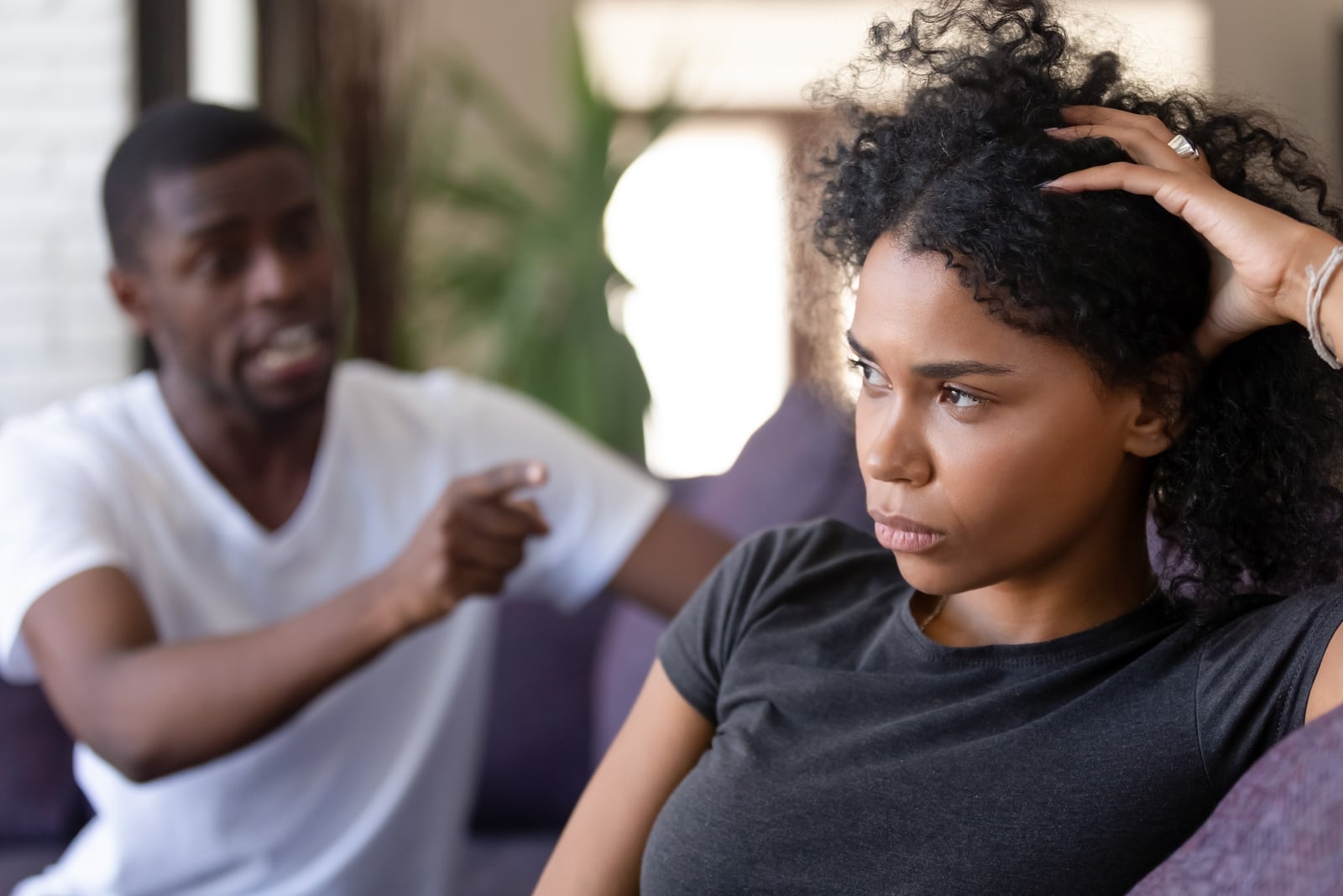 man yelling at woman while sitting on sofa