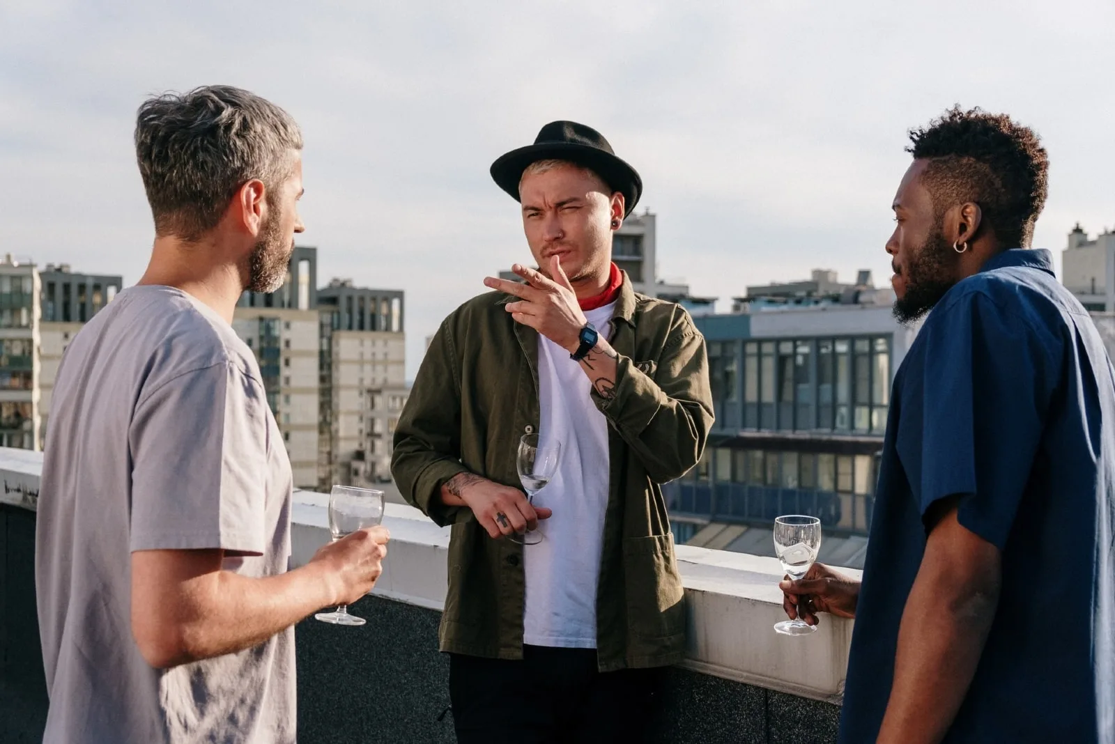 three men talking while standing on rooftop
