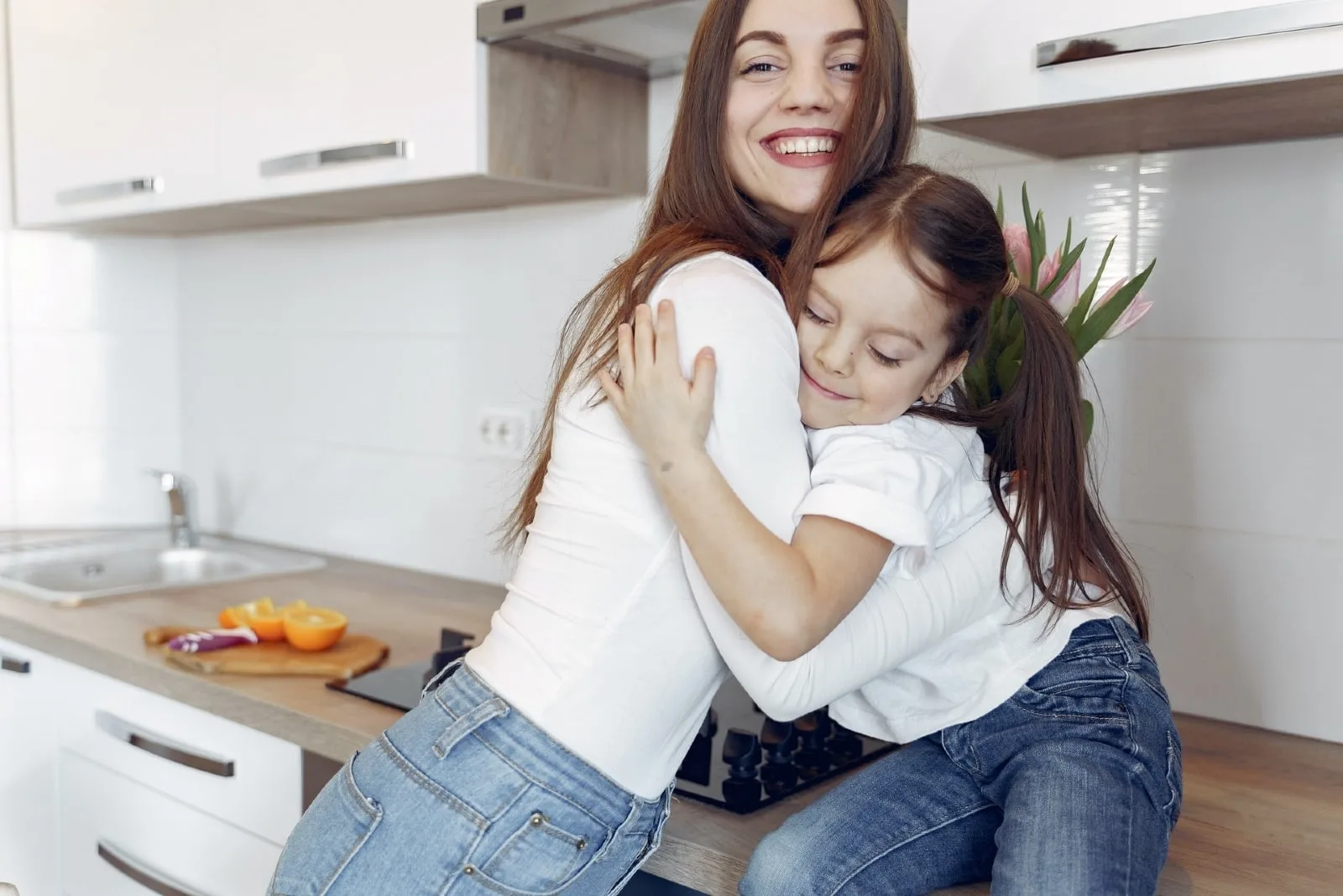 mother and daughter hugging in the kitchen