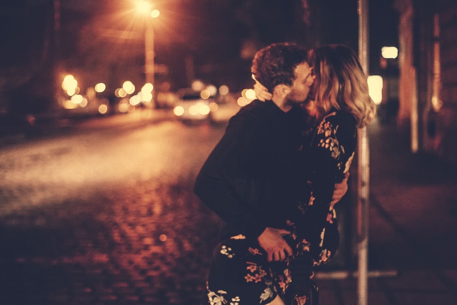 passionate lovers kissing near the street light during the night in the street