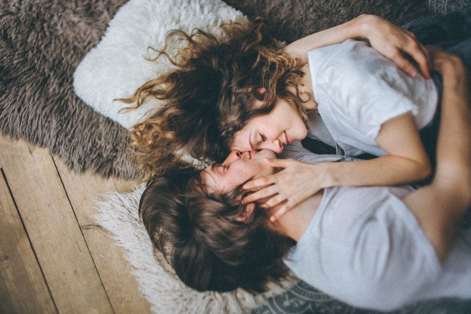 photo of a couple in love hugging and kissing forehead while lying down 