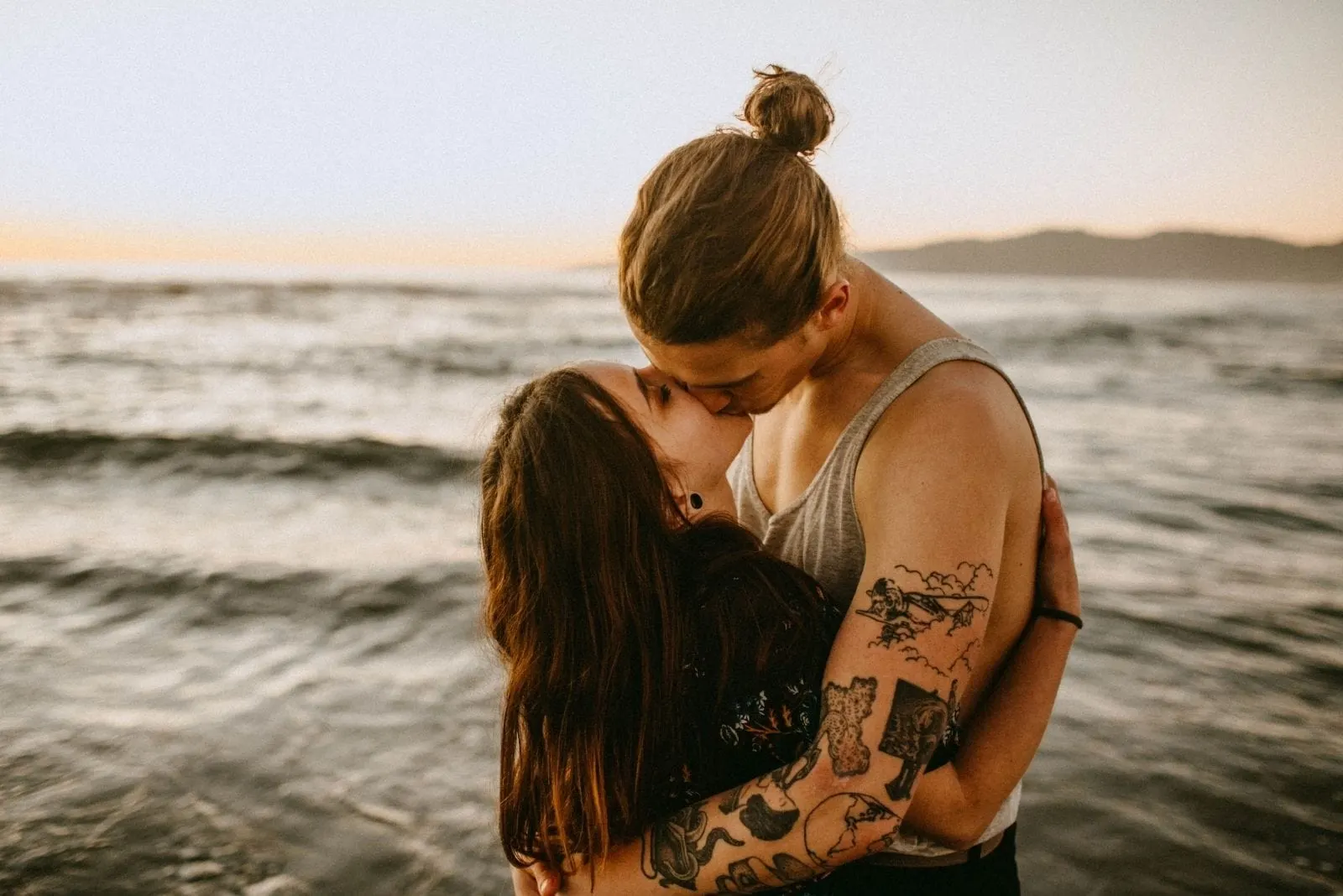 photo of kissing couple in the middle of the waters outdoors during the day