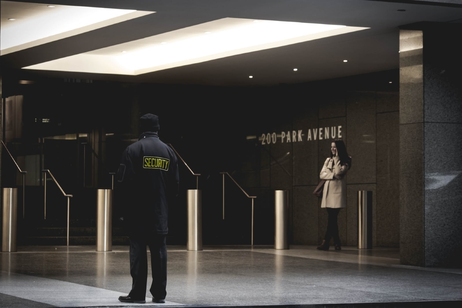 guardia di sicurezza in piedi sul pavimento grigio vicino a una donna