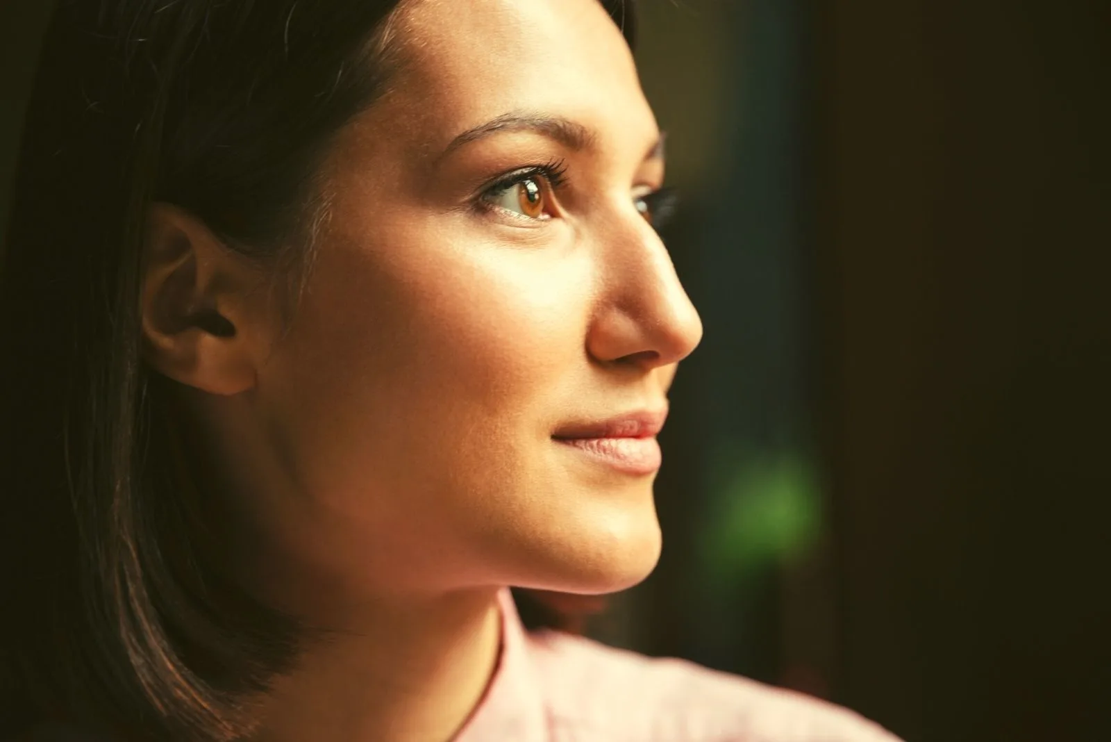smiling brunette woman in sideview with focus of the face