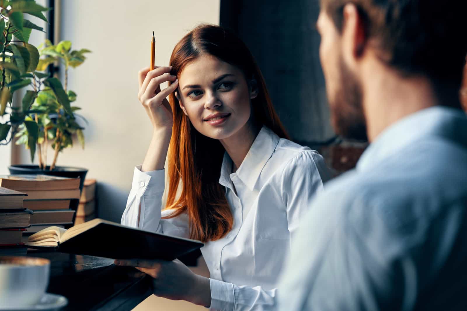 the woman sits at the table and talks to the man