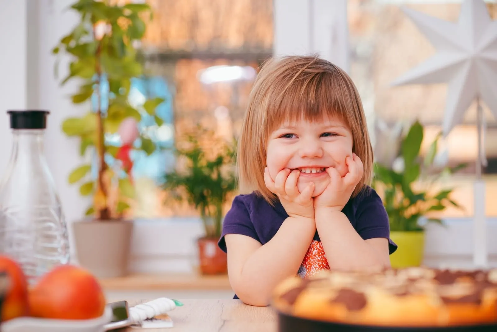 toddler smiling while sitting at table