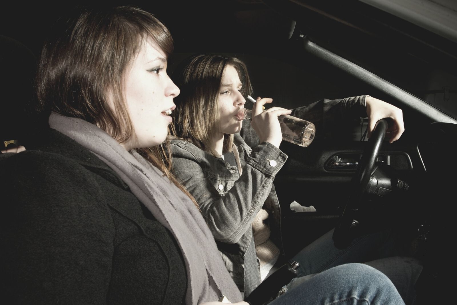 due donne all'interno dell'auto che bevono mentre guidano