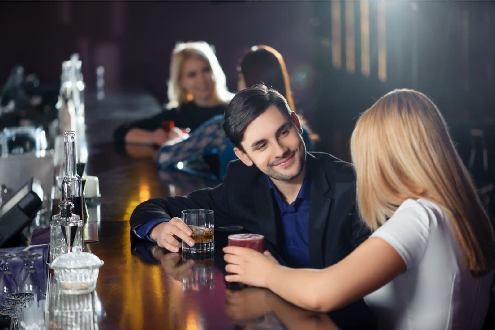 donna e uomo che bevono birra al bancone del bar 