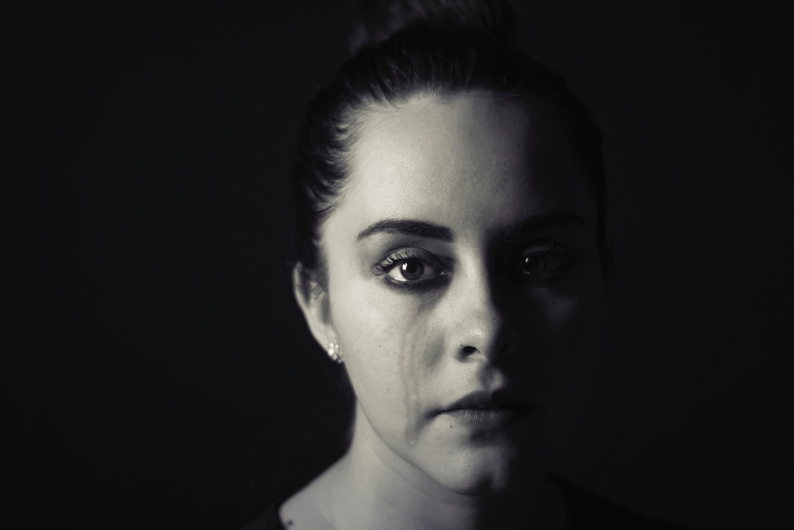 woman crying while standing near wall