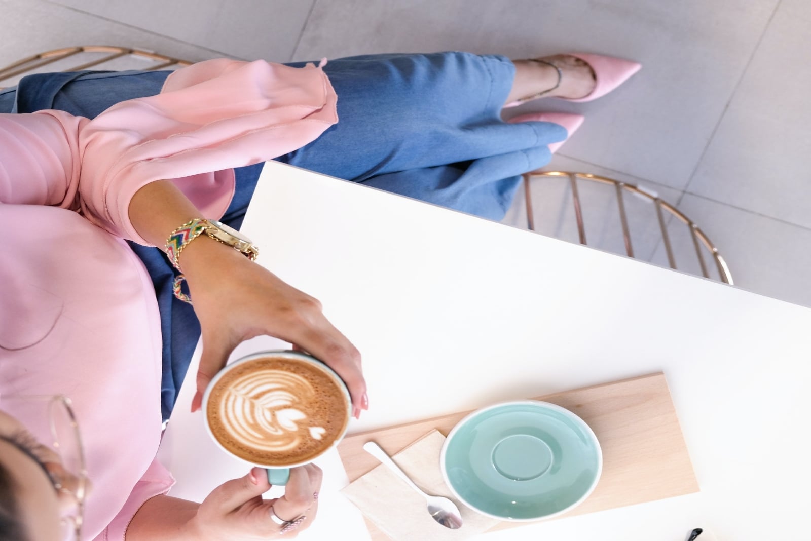 mulher a beber café sentada à mesa