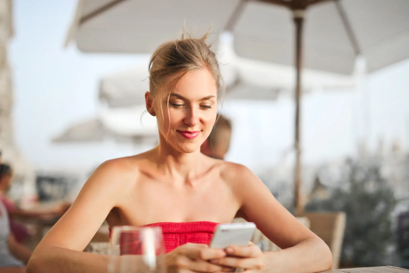 woman holding smartphone while sitting on chair