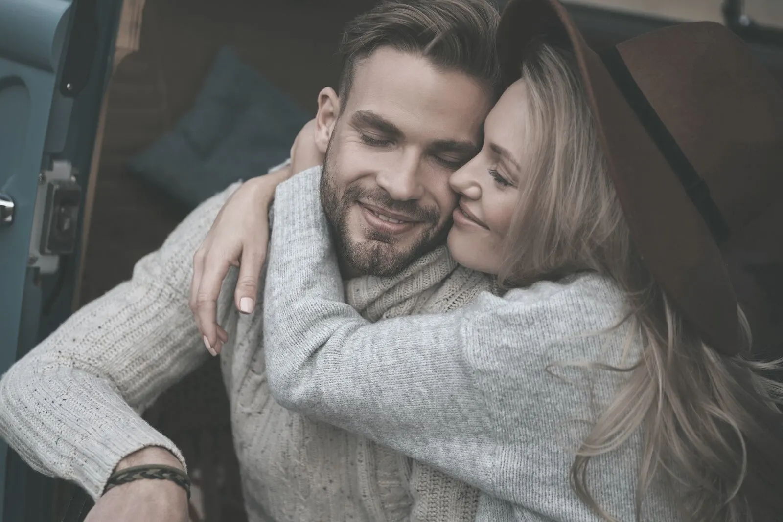 woman hugging the man while kissing him and both closing eyes