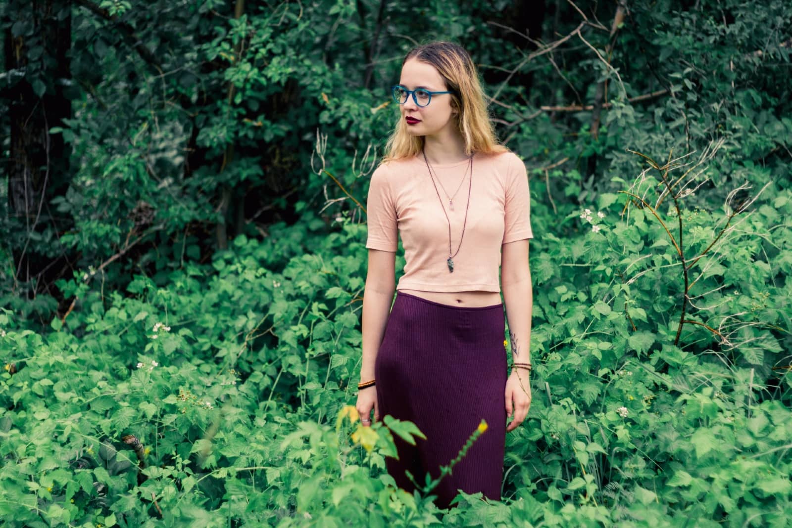woman with eyeglasses standing in forest