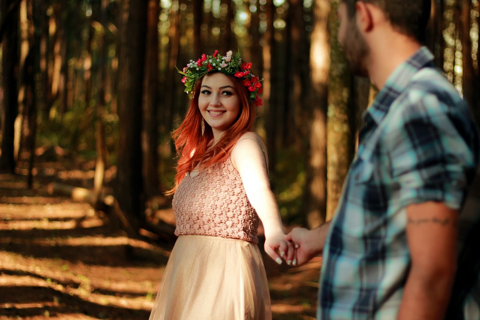 woman looking at man while standing in forest