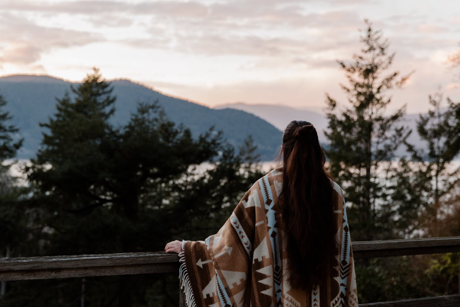 mujer de pelo largo mirando la montaña