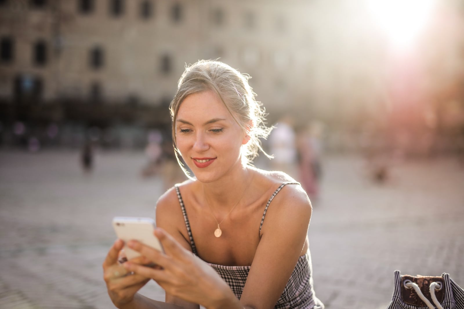 woman looking at phone while sitting outdoor