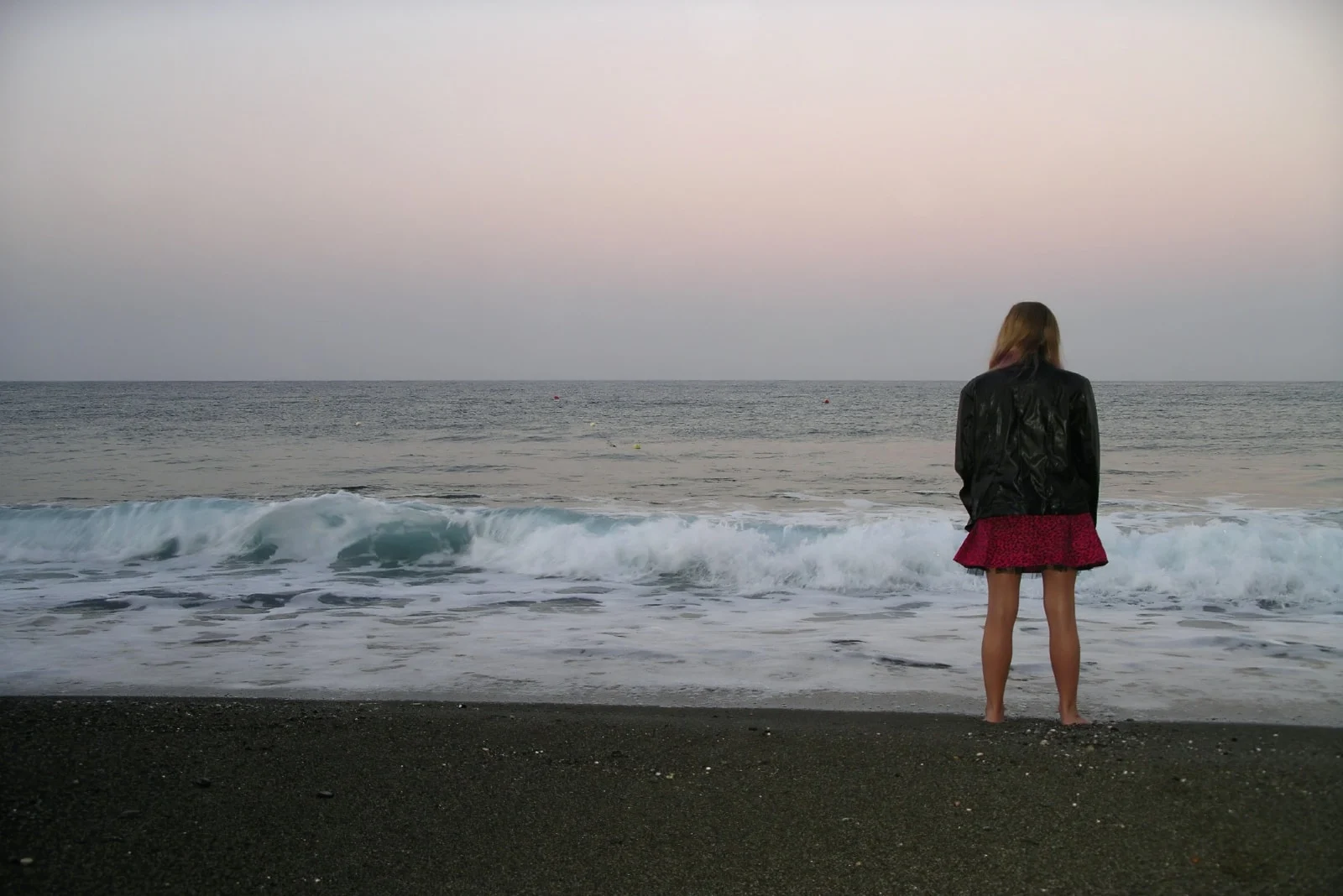 woman in black jacket looking at sea