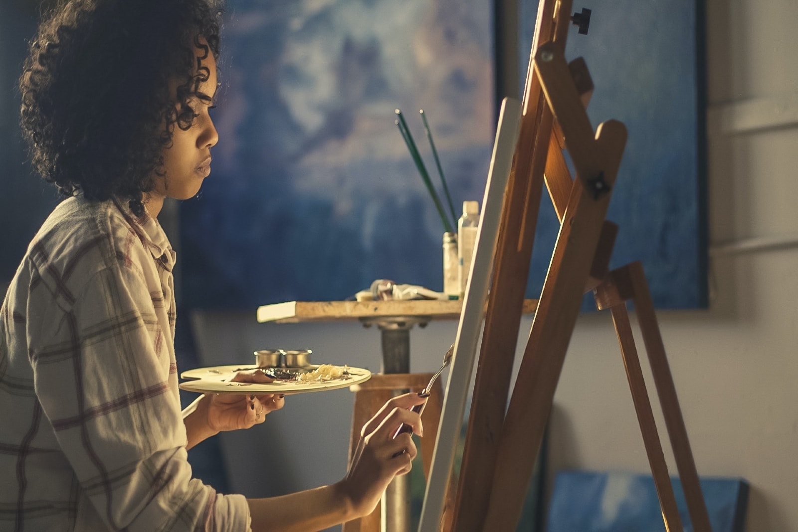 woman with curly hair painting