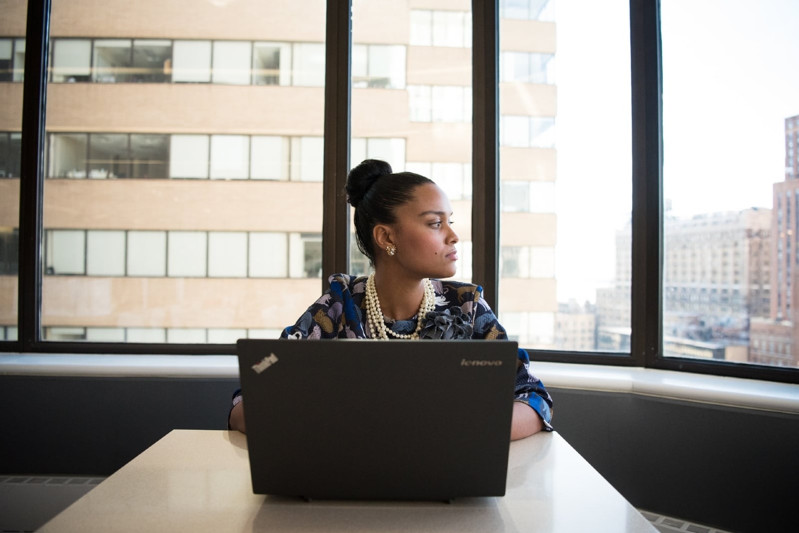 woman sitting in front of black laptop in office