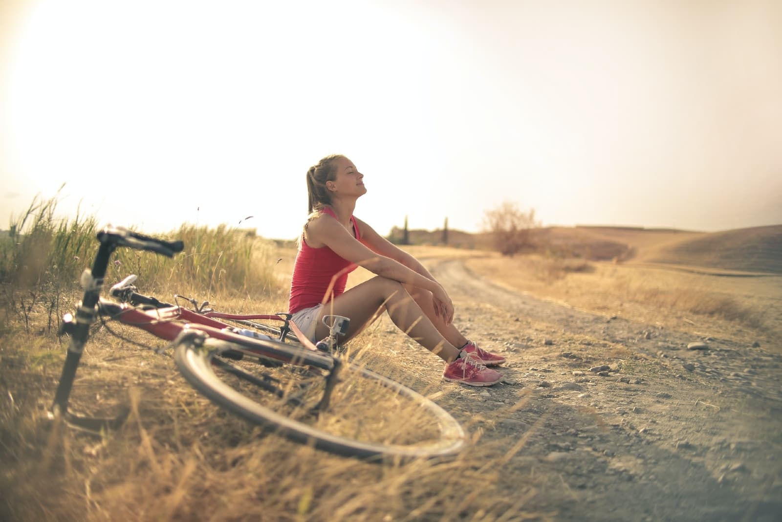 mulher sentada no chão perto de uma bicicleta