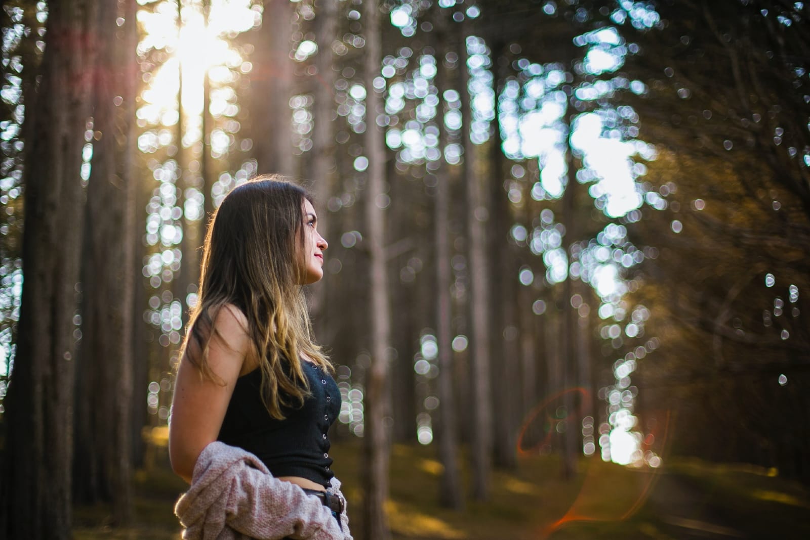 mujer con top negro de pie en el bosque