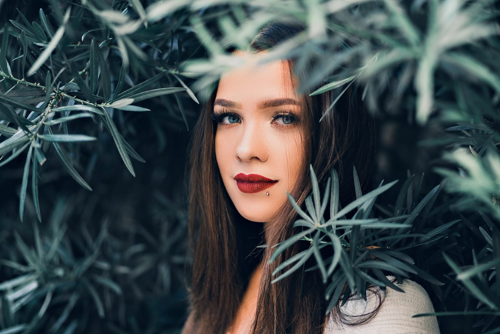 woman with blue eyes standing near tree